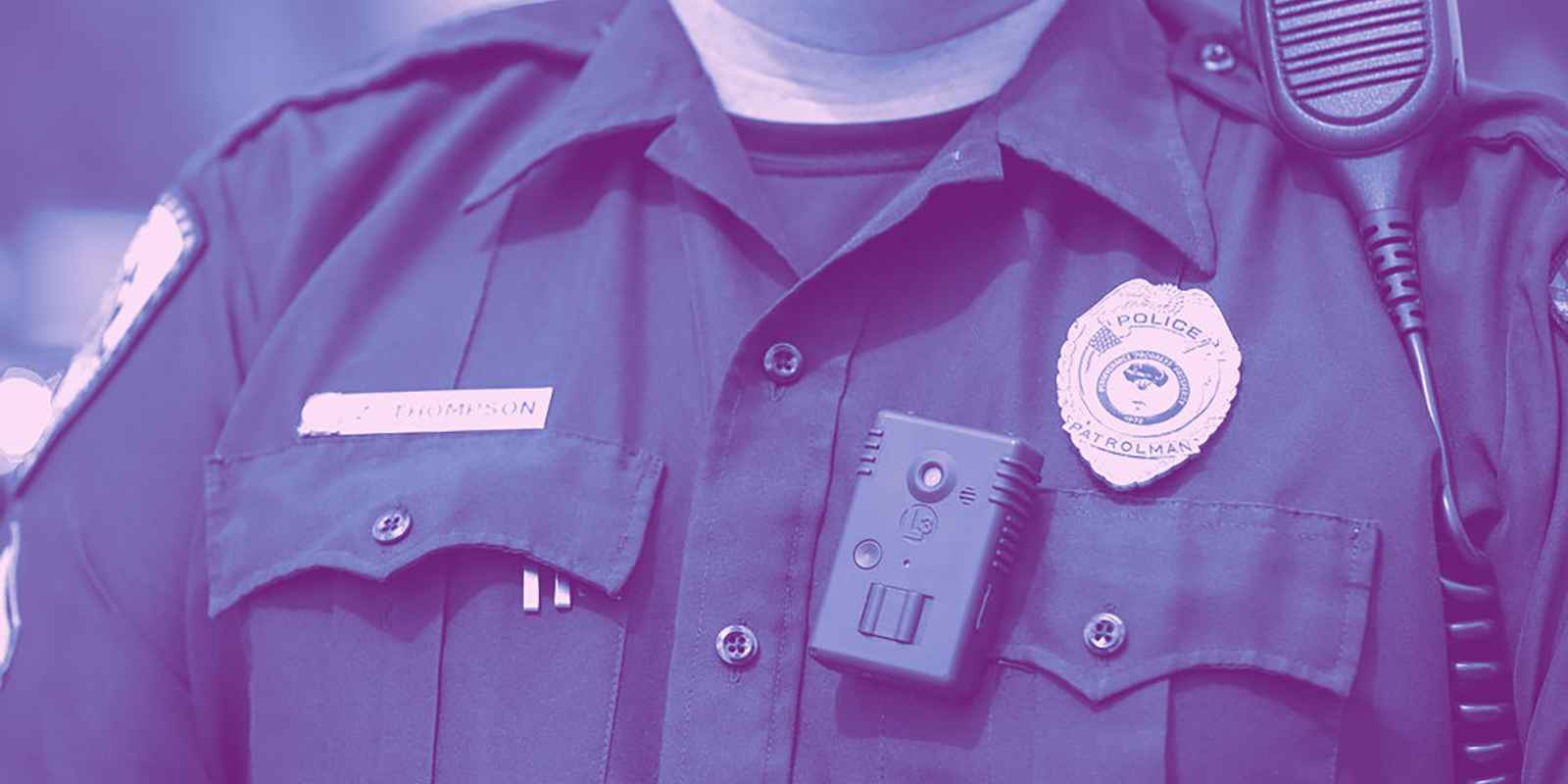 Photo of a police officer wearing a badge, body camera and radio