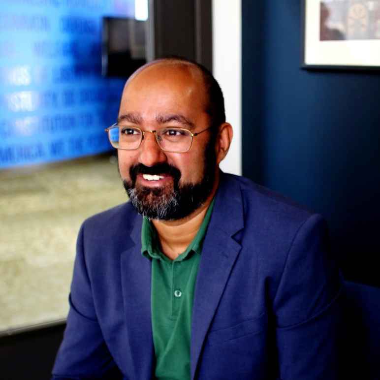 Photo of Deepinder wearing a blue blazer and sitting in his office. 