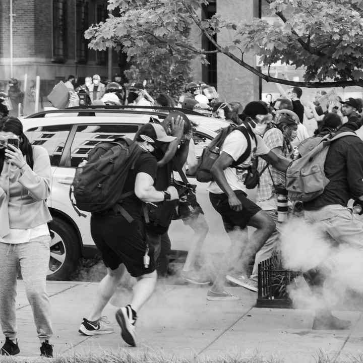 Black Lives Matter Protestors run as tear gas is dispensed into the crowd.