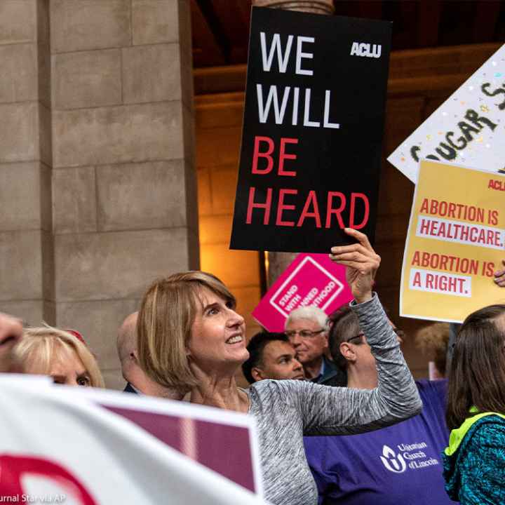 Supporters of abortion-rights attend a reproductive freedom rally at state capitol in Nebraska, holding ACLU signs that read "We will be heard" and "abortion is healthcare."