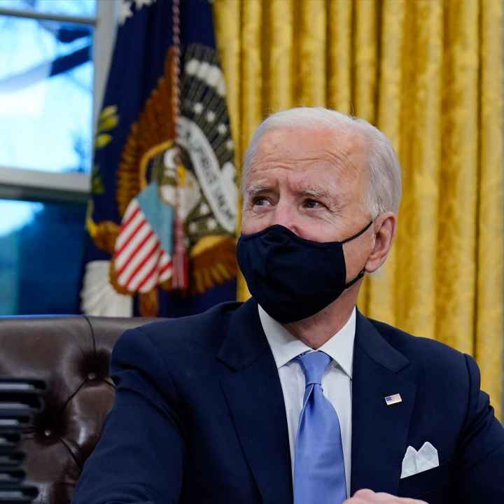 A photo of President Biden in the Oval Office wearing a mask.